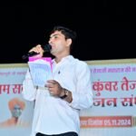 राजस्थान के प्रसिद्ध मंच संचालक और शिक्षक रमेश मिर्धा, पारंपरिक परिधान में मंच पर प्रभावशाली अभिव्यक्ति के साथ।