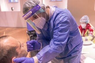 कोविड जांच केंद्र में लोग, भारत जून 2025